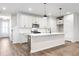 Modern kitchen features white cabinets, stainless steel appliances, an island, and wood-look floors at 686 Smokey Quartz Way, Kennesaw, GA 30144