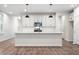 Modern kitchen boasts white cabinets, stainless steel appliances, and a large island with pendant lighting at 686 Smokey Quartz Way, Kennesaw, GA 30144