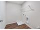 Practical laundry room includes a white wire shelf for storage and durable wood-look flooring at 686 Smokey Quartz Way, Kennesaw, GA 30144