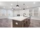 Spacious living room featuring a fireplace, large windows, stylish lighting, and wood-look flooring at 686 Smokey Quartz Way, Kennesaw, GA 30144