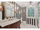 Elegant bathroom featuring striped wallpaper, marble vanity, and decorative lighting at 1762 Nancy Creek Bluff, Atlanta, GA 30305