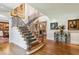 Grand foyer showcasing a curved staircase with iron railings and hardwood floors at 1762 Nancy Creek Bluff, Atlanta, GA 30305