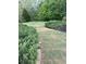A backyard with well-maintained green grass, lush bushes and mature trees providing shade at 416 Telfair Way, Canton, GA 30115