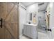 Bathroom with a modern vanity, sliding barn door, and tiled shower with bench at 416 Telfair Way, Canton, GA 30115