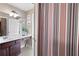 Bathroom view with striped shower curtain, double vanity, and bright vanity lighting at 416 Telfair Way, Canton, GA 30115