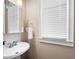 Clean powder room with a pedestal sink, mirror, and a window for natural light at 416 Telfair Way, Canton, GA 30115