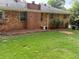 Backyard featuring lush green lawn and mature shrubs extending to a brick exterior at 5535 Beaver Sw Dr, Mableton, GA 30126