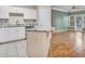 Open-concept kitchen with granite countertops seamlessly connected to a living area with wooden floors at 1850 Cotillion Dr # 3305, Atlanta, GA 30338