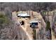 Aerial view shows home and outbuildings and pool area on wooded lot at 1370 Cronic Town Rd, Auburn, GA 30011