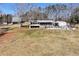 View of home with pool, deck and multiple storage and outbuildings on open lot at 1370 Cronic Town Rd, Auburn, GA 30011