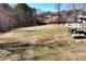 Large backyard with a fenced pool area, propane tank and construction in progress in the distance at 1370 Cronic Town Rd, Auburn, GA 30011