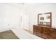 Bedroom featuring a wooden dresser with mirror and comfortable queen bed in a room with natural light and light wood floors at 2700 Pine Tree Ne Rd # 2201, Atlanta, GA 30324