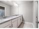 Bathroom with double sinks, granite countertop, white cabinets, large mirror, and tiled floor at 332 Hinton Farm Way, Dacula, GA 30019