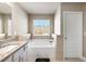 Bright bathroom features a soaking tub with tiled surround and a granite-topped vanity at 332 Hinton Farm Way, Dacula, GA 30019