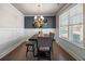 Elegant dining room with stylish chandelier, dark wood table, decorative wall paneling, and light-filled window at 332 Hinton Farm Way, Dacula, GA 30019