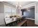 Dining room featuring a large window, modern light fixture, and dark wood table with seating at 332 Hinton Farm Way, Dacula, GA 30019