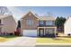 Two-story home with brick and gray siding and an attached two-car garage on a green lawn at 332 Hinton Farm Way, Dacula, GA 30019