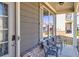 Inviting front porch featuring chairs, windows, brick accents, and a stylish door at 332 Hinton Farm Way, Dacula, GA 30019