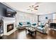 Bright living room with a fireplace, hardwood floors, and comfortable gray reclining sofas at 332 Hinton Farm Way, Dacula, GA 30019