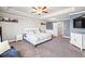 Expansive main bedroom featuring a tray ceiling, television, and stylish furniture at 332 Hinton Farm Way, Dacula, GA 30019