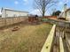 Spacious fenced backyard featuring a wooden deck, fire pit, and small playhouse at 4190 Haynes Mill Nw Ct, Kennesaw, GA 30144