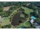 Aerial view of a pond with a surrounding golf course, swimming pool, tennis court, and parking lot at 80 Adrian Pl, Atlanta, GA 30327