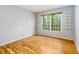 Bright bedroom with wood floors, shelving, and a large window overlooking a lush green landscape at 80 Adrian Pl, Atlanta, GA 30327