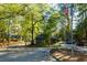 Community entrance surrounded by mature trees, landscaping, flags, and a guard house with a covered entrance at 80 Adrian Pl, Atlanta, GA 30327