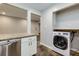 Well-equipped kitchen with stainless steel dishwasher, white cabinets, and adjacent laundry at 80 Adrian Pl, Atlanta, GA 30327