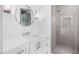 Contemporary bathroom offers a glass shower door, bright vanity, and round mirror at 819 Loridans Ne Dr, Atlanta, GA 30342