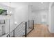 Bright hallway with wood floors, modern chandelier, and black metal staircase railing at 819 Loridans Ne Dr, Atlanta, GA 30342