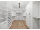 Spacious walk-in closet featuring custom shelving, cabinets, drawers, and hardwood floors at 819 Loridans Ne Dr, Atlanta, GA 30342