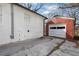 Back of home features a brick garage, white painted brick, and a concrete parking pad at 556 Holly Nw St, Atlanta, GA 30318