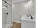 Modern bathroom features a double sink vanity with matte black hardware and a glass shower at 556 Holly Nw St, Atlanta, GA 30318