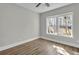 Bright bedroom features wood floors, a ceiling fan, and natural light from a window at 556 Holly Nw St, Atlanta, GA 30318