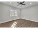 Light-filled bedroom featuring wood-look floors, a ceiling fan, and a window at 556 Holly Nw St, Atlanta, GA 30318