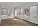 Bright sunroom features wood flooring, white painted brick and wall-to-wall windows with natural light at 556 Holly Nw St, Atlanta, GA 30318
