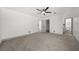 Spacious bedroom with neutral gray carpet, a ceiling fan, and access to a private bathroom at 7256 Attache Way, Riverdale, GA 30296
