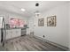Bright dining area with stainless steel appliances, white cabinets, gray backsplash and wood style flooring at 7256 Attache Way, Riverdale, GA 30296