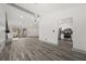 View of the open concept living room with gray wood floors, and open to the kitchen and sunroom at 7256 Attache Way, Riverdale, GA 30296