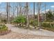 Serene backyard featuring lush trees, paved walkways, and multiple seating areas at 3620 Highpoint Rd, Cumming, GA 30041