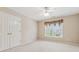 A bedroom featuring neutral carpet, a window overlooking the neighborhood, and a double-door closet at 3620 Highpoint Rd, Cumming, GA 30041