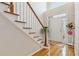 Sunlit foyer boasting hardwood flooring, staircase with wood railing, and a classic white front door at 3620 Highpoint Rd, Cumming, GA 30041