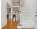 Bright foyer with gleaming hardwood floors, staircase with white carpet, and view to formal living spaces at 3620 Highpoint Rd, Cumming, GA 30041