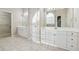 Bright main bathroom featuring double vanities with white cabinets, tile floors, and a large mirror at 3620 Highpoint Rd, Cumming, GA 30041