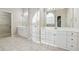 Main bathroom featuring double sinks, quartz countertops, tile floors, and a door to the walk-in closet at 3620 Highpoint Rd, Cumming, GA 30041