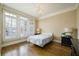 Bedroom with hardwood floors, large windows, and a stylish light fixture at 5029 Tarry Glen Dr, Suwanee, GA 30024