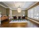 Dining room with coffered ceiling, chandelier, hardwood floors, and plantation shutters at 5029 Tarry Glen Dr, Suwanee, GA 30024