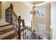 Grand foyer showcasing a staircase with iron railings and a chandelier above the entry at 5029 Tarry Glen Dr, Suwanee, GA 30024