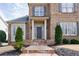 Close up of a brick home's front entrance with columns and manicured bushes at 5029 Tarry Glen Dr, Suwanee, GA 30024